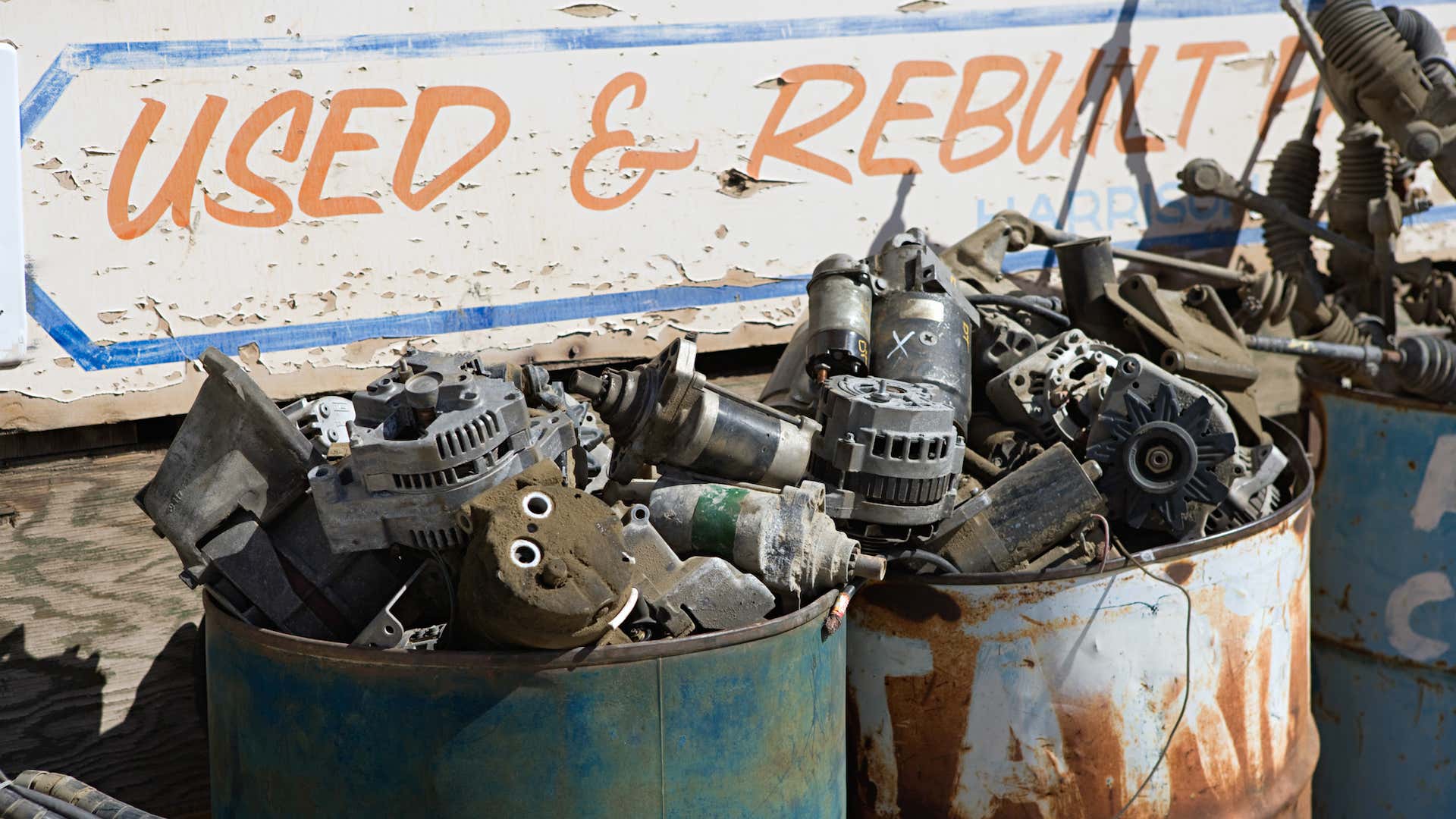 两个装满废弃零件的金属罐，如交流发电机和起动机。