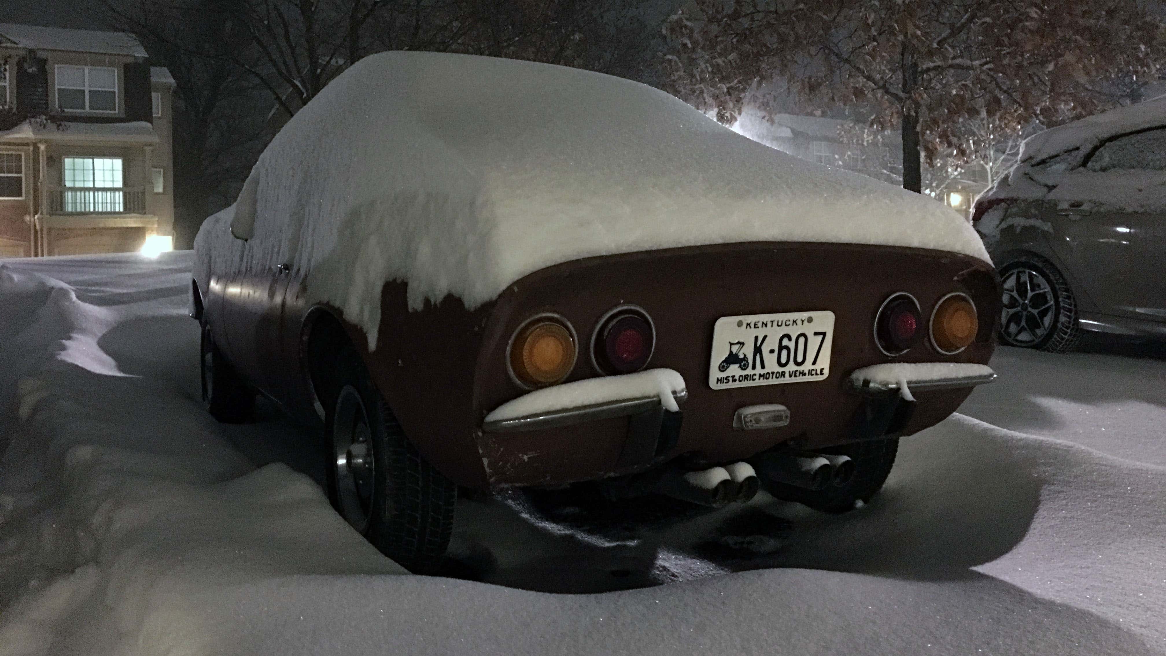 欧宝gt坐在埋在雪中的停车场。