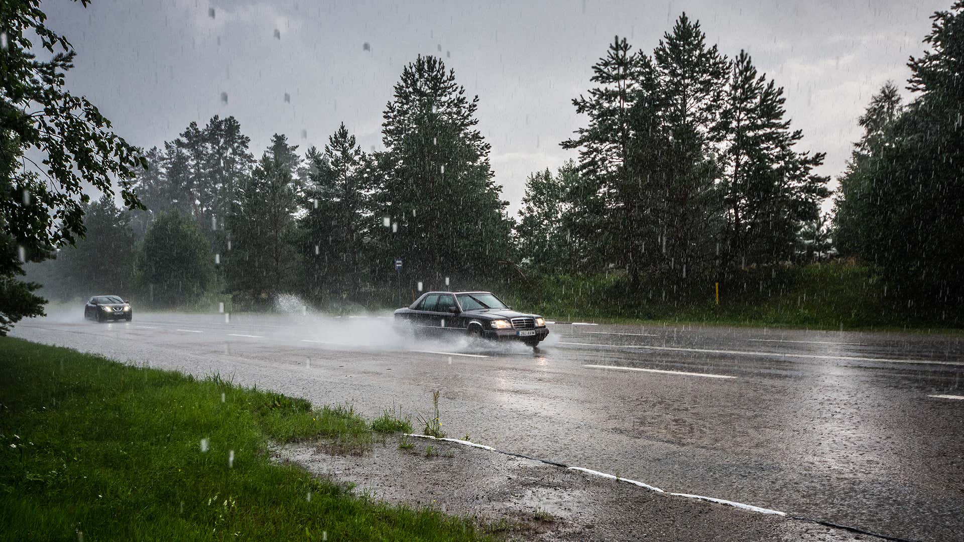 一辆奔驰轿车在雨中行驶。