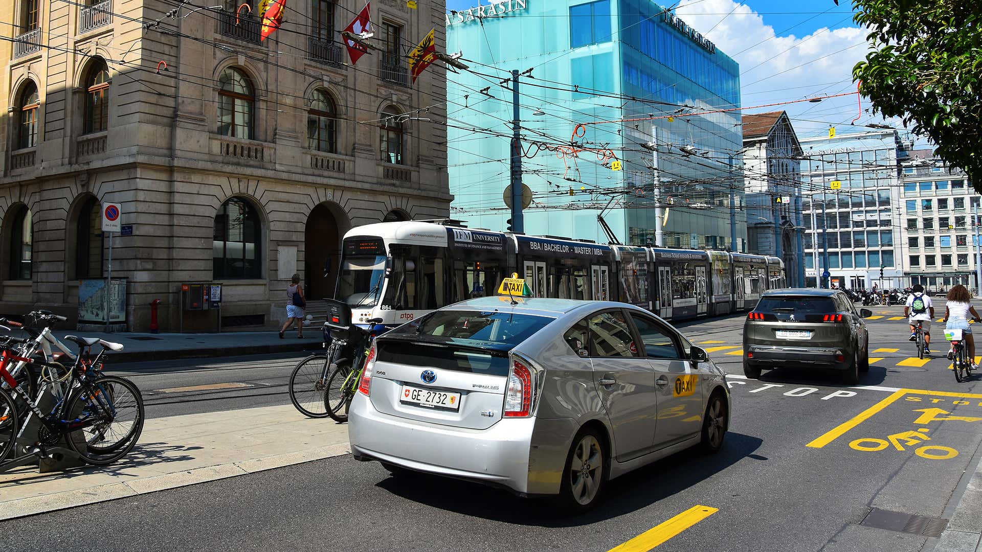 银色丰田普锐斯在一个繁忙的城市交叉路口后面停止了标致。